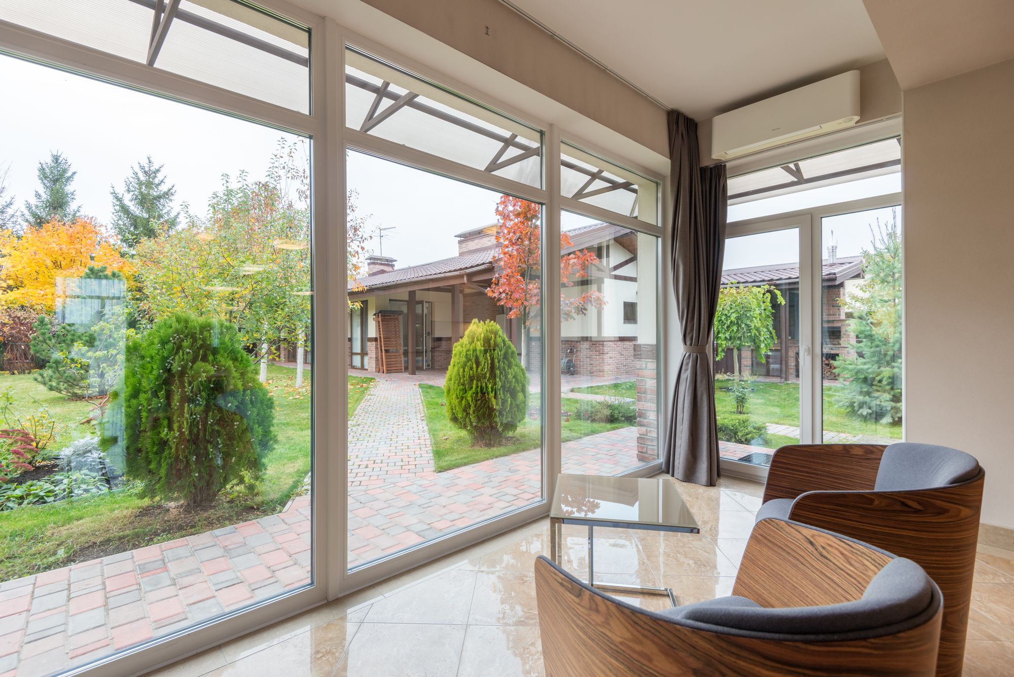Interno contemporaneo con ampie vetrate affacciate sul giardino